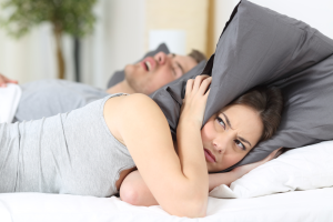 woman annoyed by mans snoring